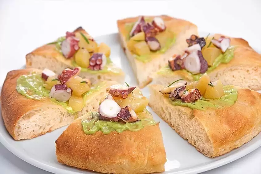 Focaccia gastronomique de farine de meule avec poulpe et pommes de terre