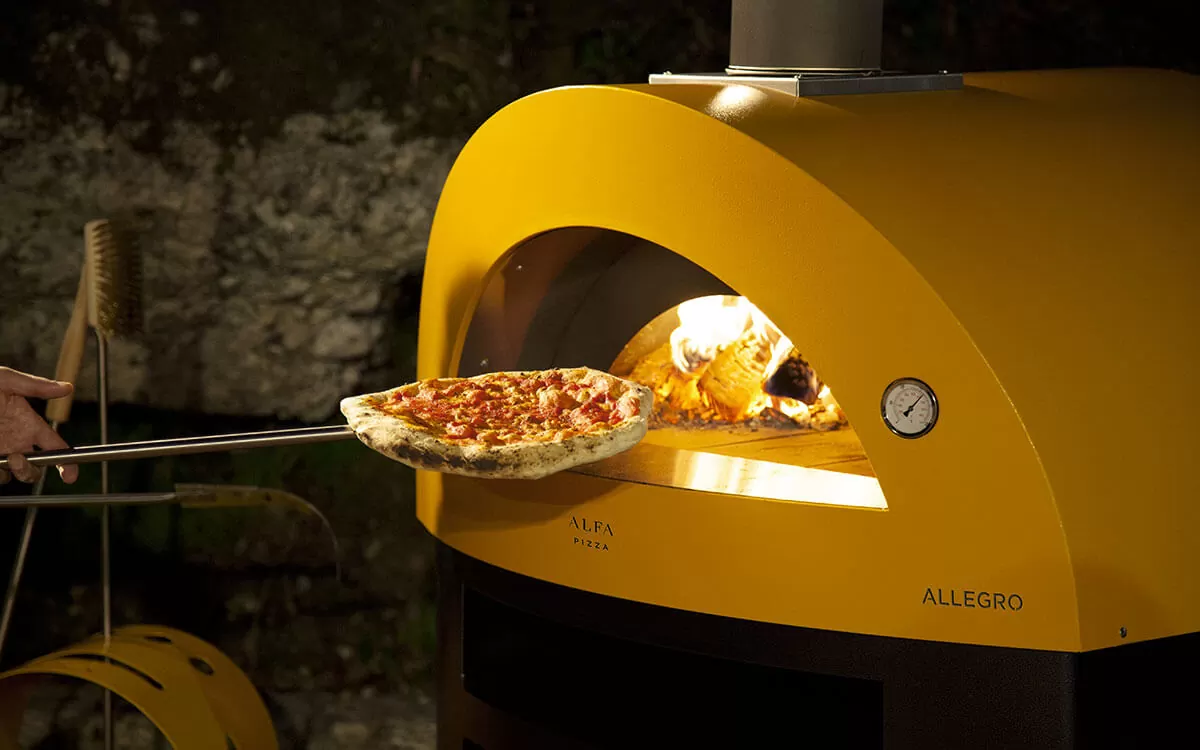 cooking-pizza-wood-fired-pizza-oven-allegro-yellow-color Forni per pizza da esterno: 5 motivi per scegliere Alfa a casa tua